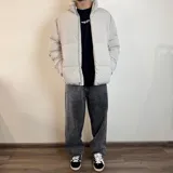 Campera puffer color beige con cierre frontal y cuello alto.