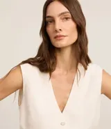 Chaleco largo color crema, con botones delanteros y lazo en la espalda.