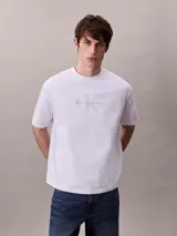 Remera blanca de algodón regenerativo con cuello redondo, corte regular y mangas cortas. Presenta el logotipo de Calvin Klein bordado en el frente.