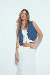 Top corto color marrón, con escote cuadrado y breteles anchos con volados. Presenta frunces horizontales en el torso y una hilera de botones nacarados en el centro frontal.