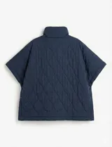 Poncho acolchado color mostaza con cuello alto y abertura frontal con cierre. Presenta un patrón capitoné de formas ovaladas y bolsillos delanteros.