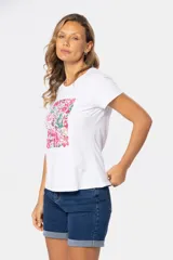 Remera blanca de algodón y poliéster con cuello redondo y mangas cortas. Estampado floral en el frente con tonos rosados, rojos y verdes.
