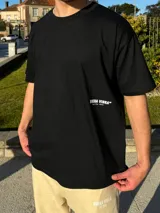 Remera color beige de corte semi oversize con estampa blanca en la espalda con la frase "Buena Vibra" y "feel the vibes".