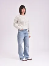Sweater de punto calado color crudo, de corte holgado y mangas largas.