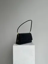 Cartera negra de hombro con textura tipo cocodrilo, doble compartimento interno, dije metálico con la letra B y cierre con broche imán.