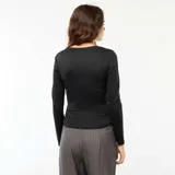 Camiseta negra cropped de manga larga con efecto arrugado en los laterales.