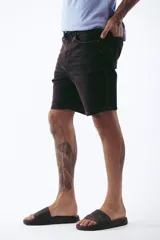 Bermuda de jean negra con corte a la rodilla.