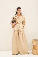 Camisa beige de poplin amplia, con botones laterales para abotonar de forma cruzada.