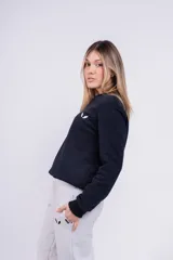 Buzo negro de algodón de corte clásico con cuello redondo y mangas largas. Tiene un pequeño logo bordado en el pecho.