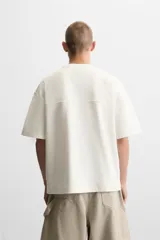 Camiseta negra de corte cuadrado, con cuello redondo, mangas cortas y efecto lavado.