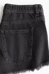 Short de jean negro con tiro alto, corte holgado, cinco bolsillos y bajo desflecado.