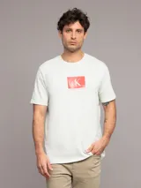 Remera blanca de manga corta con cuello redondo y logo de Calvin Klein en un recuadro rojo.