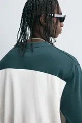 Camiseta de manga larga con cuello redondo, diseño color block en blanco y verde oscuro, con el número 80 y la inscripción 'Saint Frederic' bordados en el frente.