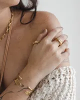 Anillo dorado con diseño de tres bandas entrelazadas.