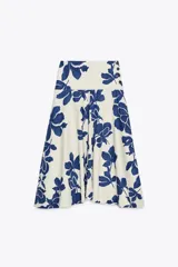 Falda midi de tiro medio confeccionada en hilatura de algodón, color blanco con estampado de flores azules. Cierre lateral con botones.
