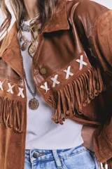 Campera marrón de gamuza con flecos y detalles en cuero sintético en la parte superior. Corte suelto.