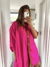 Camisola fucsia con solapa marrón, mangas 3/4 con botón y corte holgado.