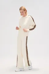 Sweater color crema con capucha y cordones, de tejido de punto, con mangas largas y detalle de franja con estampado animal en mangas y laterales.