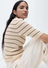 Jersey de punto de canalé color crema con rayas horizontales finas marrones, cuello perkins y manga tres cuartos.