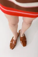 Zuecos plateados de cuero con diseño tejido y punta cuadrada.