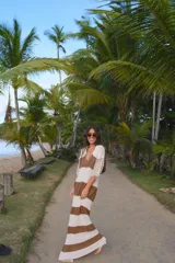 Vestido largo de tejido de punto a rayas horizontales color marrón y crudo, con cuello polo y mangas acanaladas.