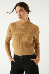 Sweater color camel de punto con diseño de ochos en el frente y mangas, cuello semi alto y corte al cuerpo.