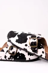 Zuecos con estampado de vaca en blanco y negro, con hebilla metálica ajustable y plantilla de corcho.