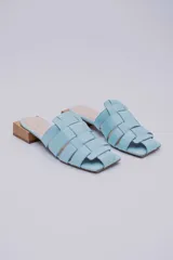 Mules de cuero celeste con diseño trenzado y taco de madera.