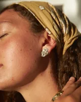 Par de aros colgantes de bronce y alpaca con diseño abstracto calado.