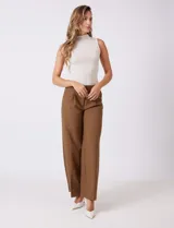 Pantalón sastrero color marrón, de tiro alto y corte recto, con un largo al tobillo. Presenta pretina limpia con cierre interno, bolsillos funcionales en la delantera y plisado que aporta volumen. La trasera tiene bolsillos ojal simulados.