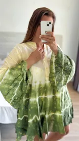 Vestido corto con estampado batik en tonos verde y amarillo, con mangas largas acampanadas y cuello mao.