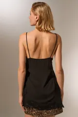 Musculosa negra de bretel fino con encaje en escote y ruedo, de corte holgado y escote profundo.