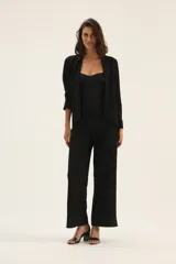 Pantalón negro con lunares blancos, de corte recto y tiro alto.