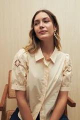 Camisa blanca de mangas cortas abullonadas con calados florales.