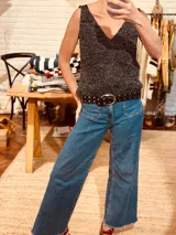 Musculosa tejida en lurex color negro con brillo plateado, de escote en V y breteles finos.