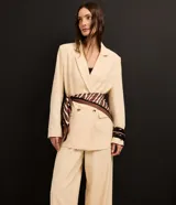 Blazer oversized color beige confeccionado en viscolino, con solapas en el cuello, botones delanteros y solapas delanteras que simulan bolsillos.