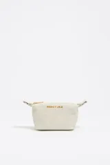 Monedero trapecio de tamaño mini, color crudo, con cierre dorado y logo de la marca estampado en dorado.