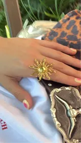 Anillo dorado con forma de sol, regulable.