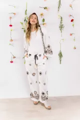 Pantalón blanco de corte recto con bordados de flores en color beige y negro.