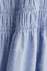 Vestido corto celeste de algodón con cuerpo fruncido, escote cuadrado y breteles spaghetti dobles. Costura fruncida en la cintura y falda con vuelo. Forrado.
