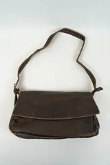 Cartera bandolera de cuero marrón oscuro con solapa y correa fina ajustable.