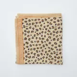 Pañuelo cuadrado de tela color beige con estampado de manchas de leopardo en marrón y negro.