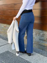 Pantalón de jean azul de corte recto y tiro alto, con cinturón de cuero negro con hebilla plateada.