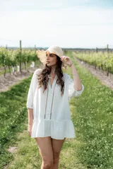 Vestido corto blanco con escote en V, mangas 3/4 y detalle de puntillas en el frente y ruedo.