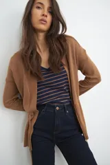 Ruana color tostado de tejido de punto, con corte holgado y diseño básico.