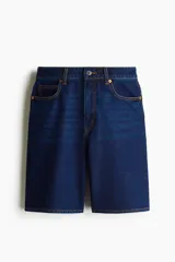 Bermuda de denim azul oscuro, de tiro alto y corte recto, con cinco bolsillos, cierre frontal con botón y trabillas para cinturón.