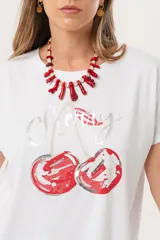 Remera blanca de manga corta con estampado de cerezas y la palabra "Cherry" en cursiva.