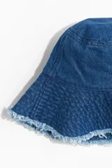 Sombrero tipo bucket de denim azul con ala ancha y terminación desflecada.