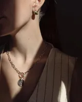 Collar plateado con cadena de eslabones y dije circular texturizado.