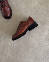 Zapatos acordonados de cuero vacuno color negro, con suela track.